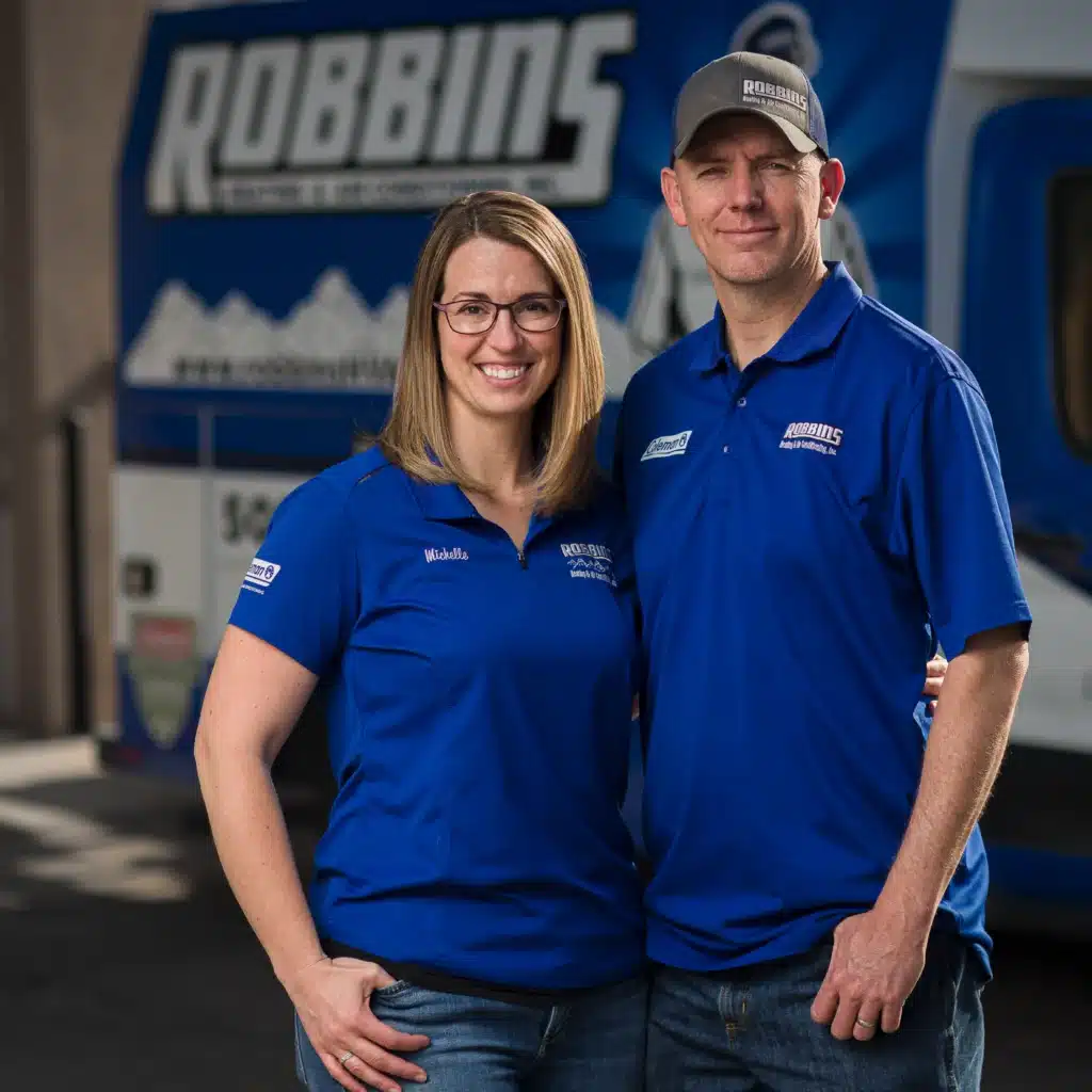 robbins heating and air conditioning owners posing for a picture in blue robbins branded shirts