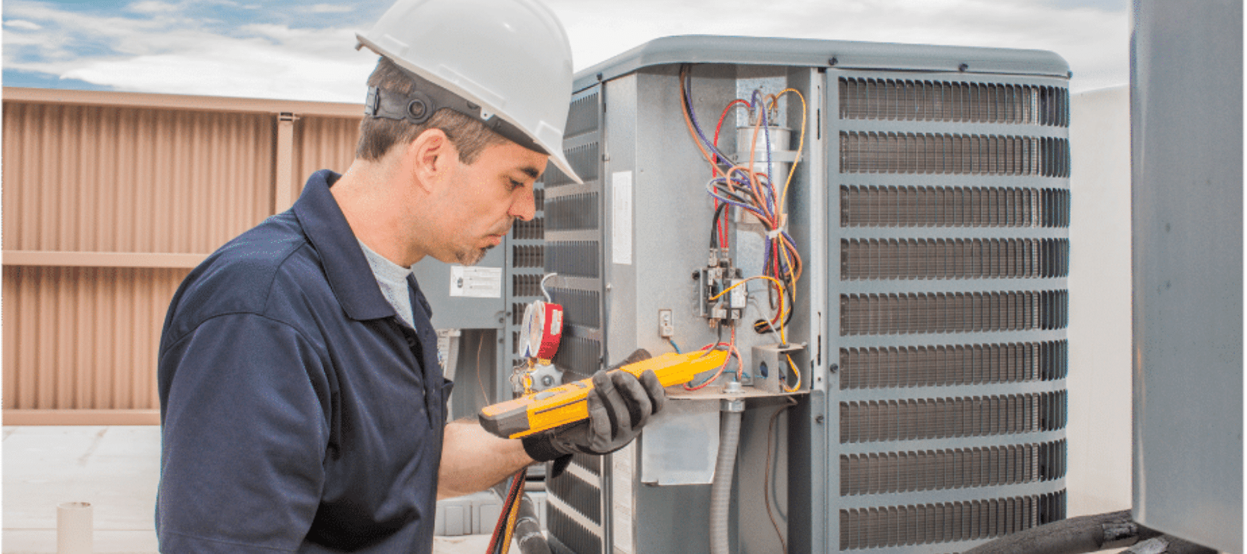 Technician inspecting and testing an HVAC unit on a commercial rooftop
