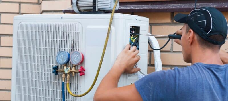 technician performing heat pump maintenance